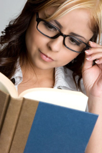 Woman with glasses reading a book. 